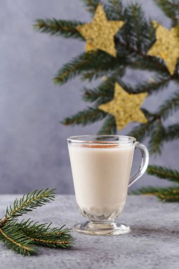 Noel arkaplanı, hediye kutuları, yıldızlar, şenlikli dekor, köknar ağacı, tarçın çubukları, sıcak eggnog içeceği.
