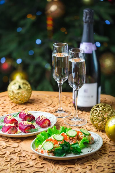 Konzept von Weihnachten. Tisch mit Lebensmitteln und Silvesterutensilien steht in einem Raum, der für Neujahr dekoriert ist — Stockfoto