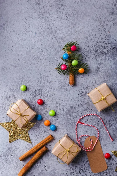 Karácsonyi háttér mini karácsonyfa, ajándékdobozok, ünnepi dekoráció, fenyő fa, cukorka, fahéj pálca — Stock Fotó