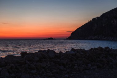 Dağ manzaralı deniz tarafından gün batımı. Karadağ 