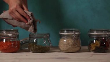 Kadın eli cam kutuda bezelye aromalı sürahi içiyor.