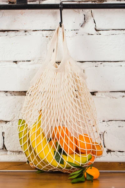 Сетка многоразового использования мешок с фруктами подключен на стене белого кирпича нулевой концепции отходов — стоковое фото