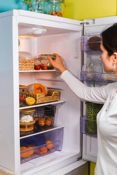 Fiatal nő keres élelmiszer a hűtőben nulla hulladék koncepció — Stock Fotó