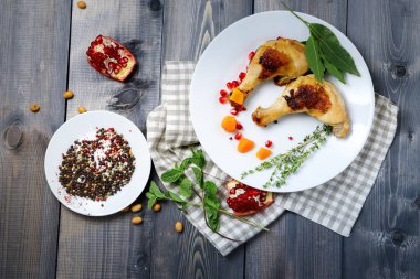 Koyu ahşap bir masanın üstünde kareli bir peçetenin üzerinde bir tabak var. 