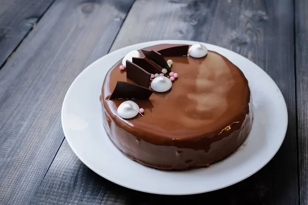 Ein großer Teil eines schokoladenglänzenden Kuchens mit hellen Schichten von — Stockfoto