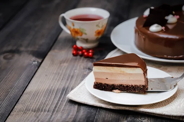 Een groot deel van een chocolade glanzende taart met heldere lagen van — Stockfoto