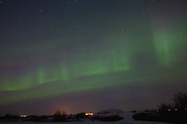 beautiful night view of houses under sky with majestic northern lights in iceland   clipart