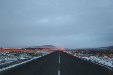 boş asfalt yol ve karla kaplı İzlanda manzara gündoğumu