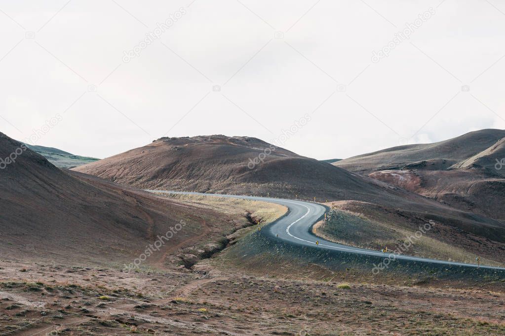 Empty asphalt road between hills in iceland
