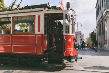 ISTANBUL, TURKEY - OCTOBER 09, 2015: people in vintage red tram clipart