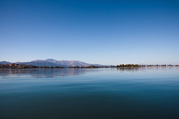 beautiful landscape with tranquil water and green vegetation on coast at sunny day, egirdir,  turkey