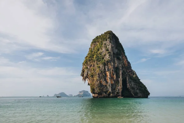 Живописная скала с зеленой растительностью в спокойном океане в Краби, Таиланд — стоковое фото