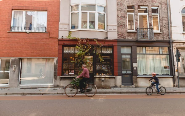 БРЮГЖ, БЕЛЬГИУМ - 02 НОЯБРЯ 2016: старший мужчина и маленький мальчик катаются на велосипедах по исторической улице Брюгге, Бельгия — стоковое фото