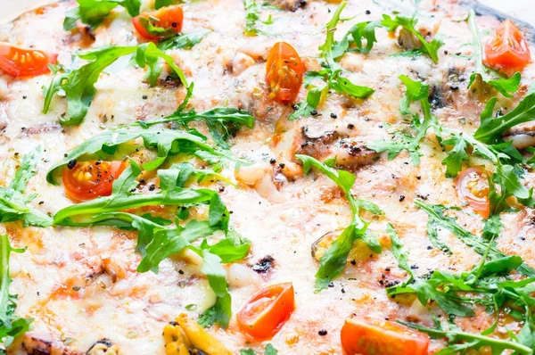 Deniz ürünleri, domates ve rucola pizza