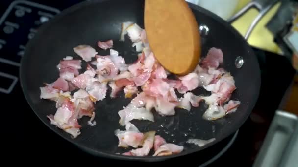 Pieces of bacon are fried in a pan — Stockvideo