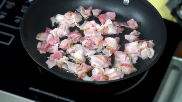 Pieces of bacon are fried in a pan — Stockvideo