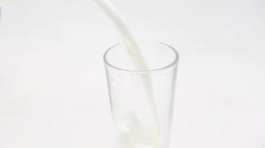 Bir bardak, şişeden çıkan sütle doludur.