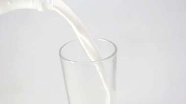 Bir bardak, şişeden çıkan sütle doludur.