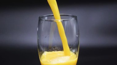 Bir portakal suyu bir bardağı doldurur.