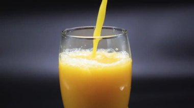 Bir portakal suyu bir bardağı doldurur.
