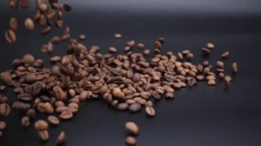 Kahve çekirdekleri siyah bir yüzeye dökülür..
