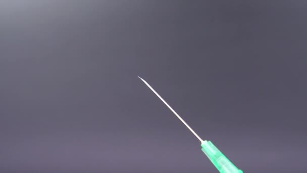 Una aguja de jeringa libera una gota de líquido transparente — Vídeos de Stock