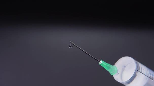 Een injectienaald laat een druppel heldere vloeistof vrij — Stockvideo