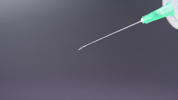 Uma agulha de seringa liberta uma gota de líquido transparente — Vídeo de Stock