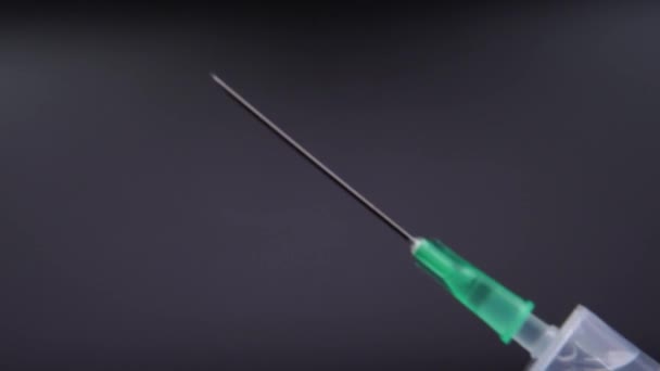 Una aguja de jeringa libera una gota de líquido transparente — Vídeo de stock