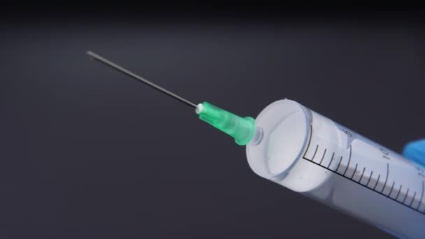 Une aiguille libère une goutte de liquide transparent 