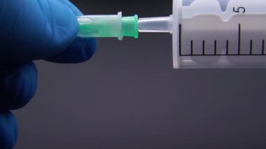 Doktor şırıngaya bir iğne takıyor.