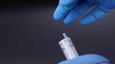 Doktor şırıngaya bir iğne takıyor.