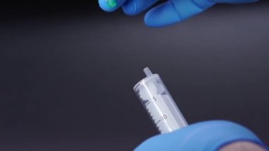 Doktor şırıngaya bir iğne takıyor.