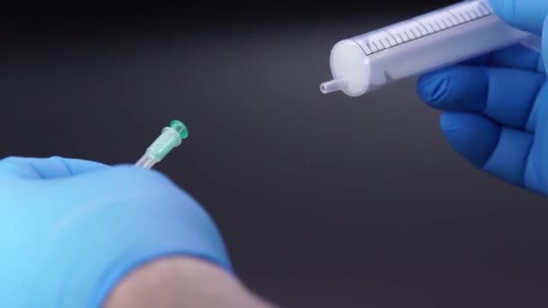 Lékař nasadí jehlu na injekční stříkačku — Stock video