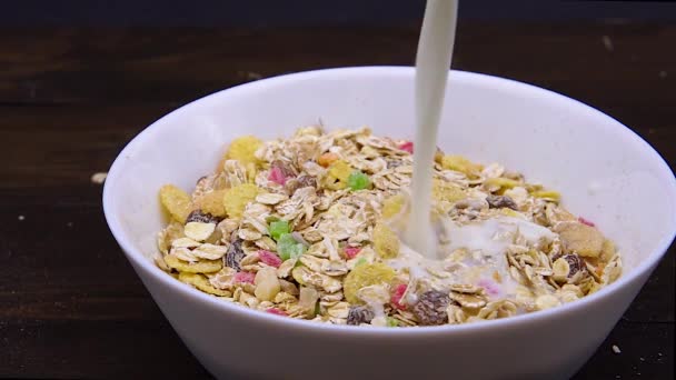 Pouring milk in bowl with flakes — Stock Video