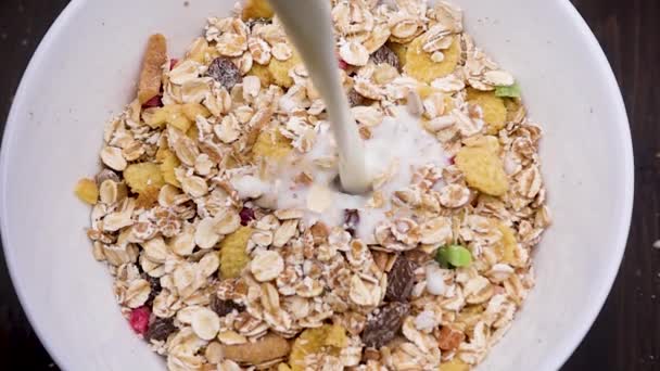 Milch in Schüssel mit Flocken gießen — Stockvideo