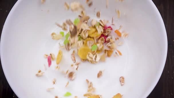 Primer plano de muesli vertido en un tazón blanco — Vídeos de Stock