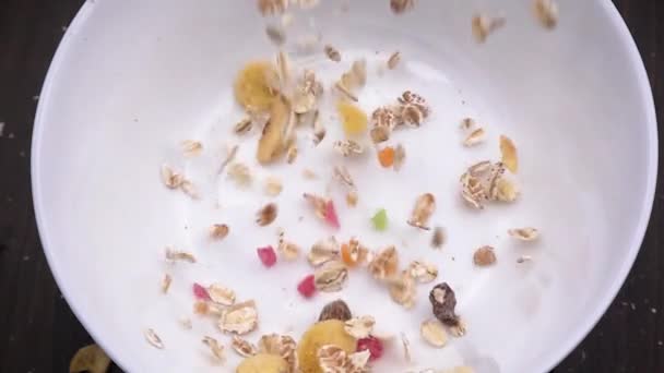 Primer plano de muesli vertido en un tazón blanco — Vídeos de Stock