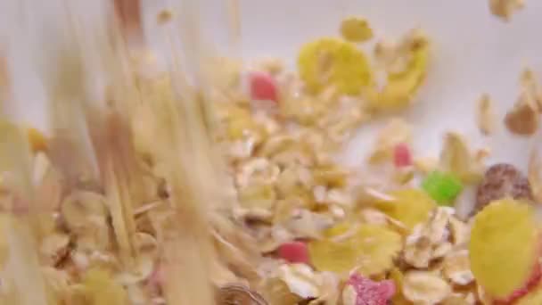 Primer plano de muesli vertido en un tazón blanco — Vídeo de stock