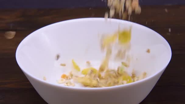 Close-up van muesli gegoten in een witte kom — Stockvideo