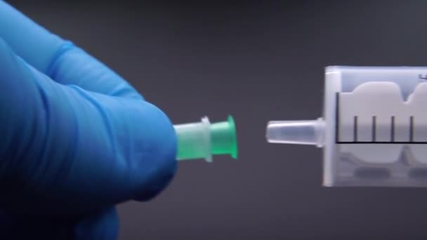 Läkaren sätter fast en nål på en spruta — Stockvideo