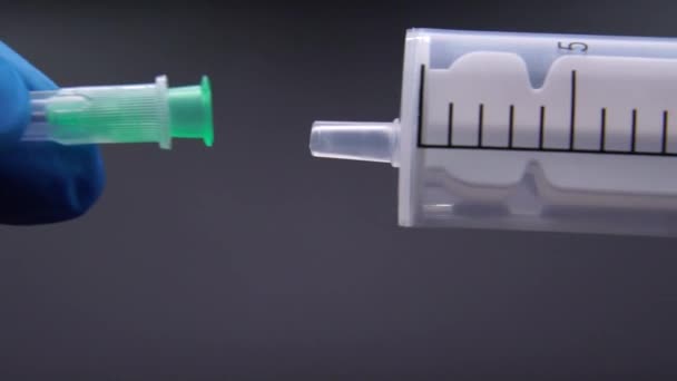 De arts bevestigt een naald aan een spuit — Stockvideo