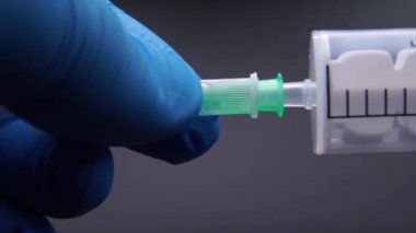 Doktor şırıngaya bir iğne takıyor.