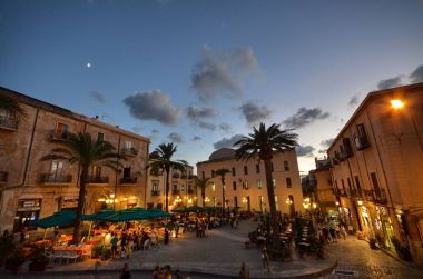 Cefal, İtalya, Sicilya 16 Ağustos 2015. Piazza del Duomo adlı yemek vakti: sarı sokak ışıkları, turistler, restoranlar açık.