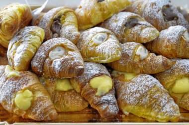 Tepsi kruvasan ile tıka basa dolu. Doldurma krem, ricotta, nutella ile. Yakın çekim tarih seçici odak.