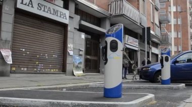 Urin, Piedmont bölgesi, İtalya. 29 Nisan 2018. Piazza Nazario Sauro. İnşaat alanında hızlı şarj sütunları Kiralık terminal aşamasındadır elektrikli arabalar için. Yatay hareketi ile HD video.