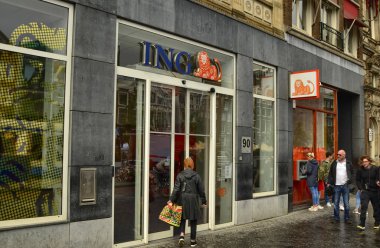 Amsterdam, Hollanda. Ağustos 2019. Şehirde, Hollanda bankası Ing Direct 'in şubeleriyle karşılaşmak kolaydır. Bir bayan giriyor. Turuncu aslan logosu aşikar. Yürüyen insanlar.