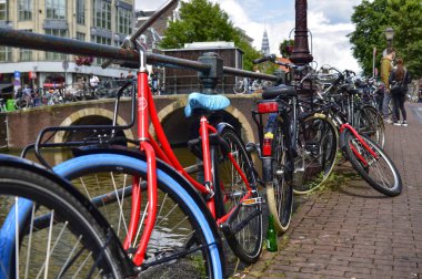 Amsterdam, Hollanda. Ağustos 2019. Kanal boyunca park etmiş bisikletler.