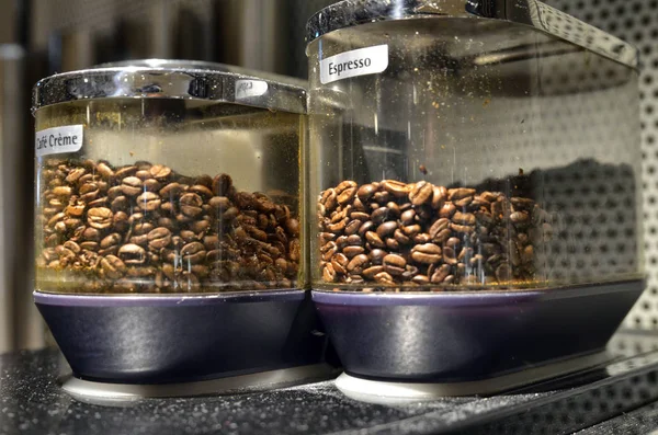 Granos de café para moler en una máquina de café expreso automática. El —  Fotos de Stock