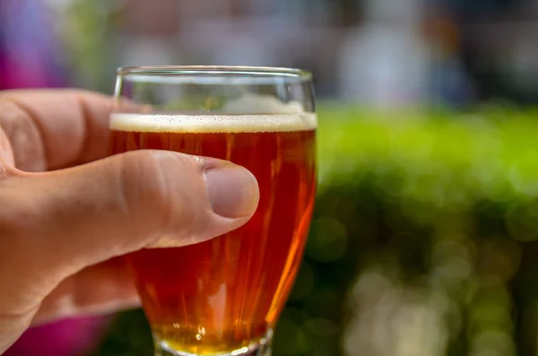 Cata de cerveza artesanal: Primer plano de la mano de un hombre caucásico — Foto de Stock